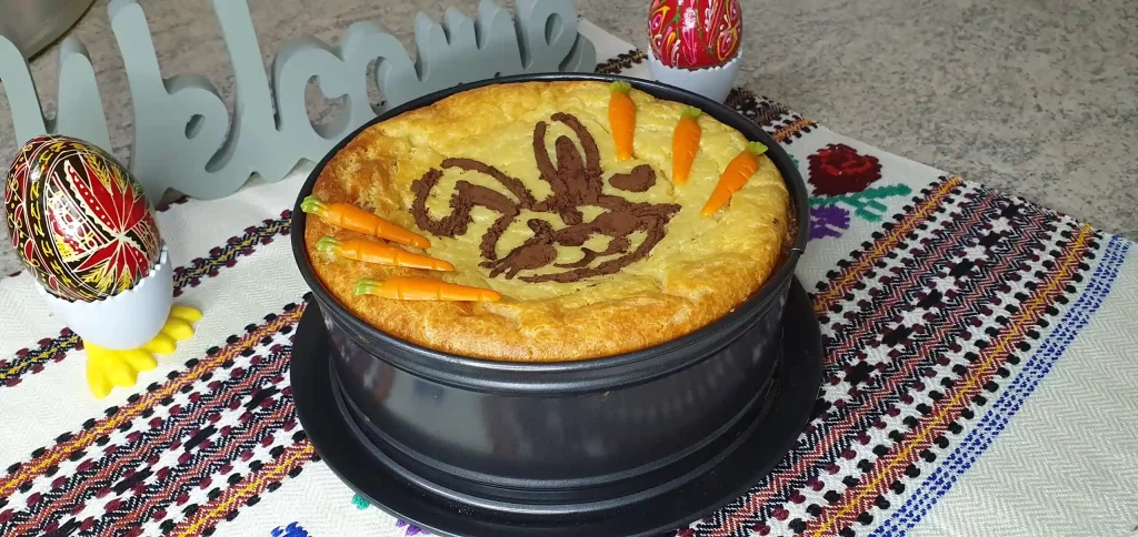 Tort cu un iepuraș decorativ, așezat într-o tavă, gata de servire.